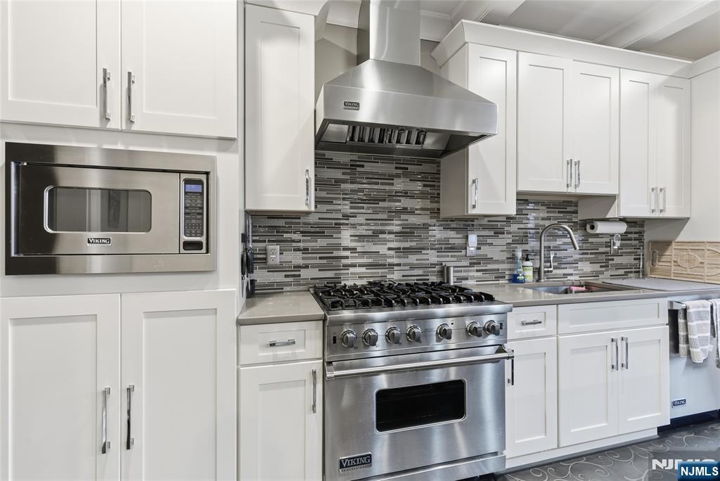 119 Hudson Cove Edgewater, NJ 07020 - Photo 7 of 44 a kitchen with granite countertop white cabinets stainless steel appliances and sink