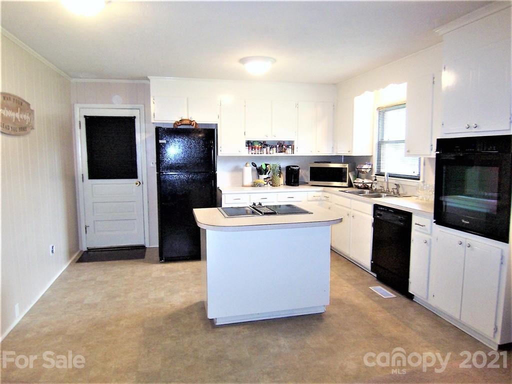 3536 Fallston Road Shelby, NC 28150 - Photo 14 of 34 a kitchen with stainless steel appliances a refrigerator a stove a microwave a sink and dishwasher with wooden floor