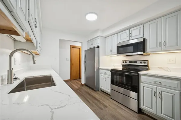 a kitchen with stainless steel appliances granite countertop a stove a sink and a microwave