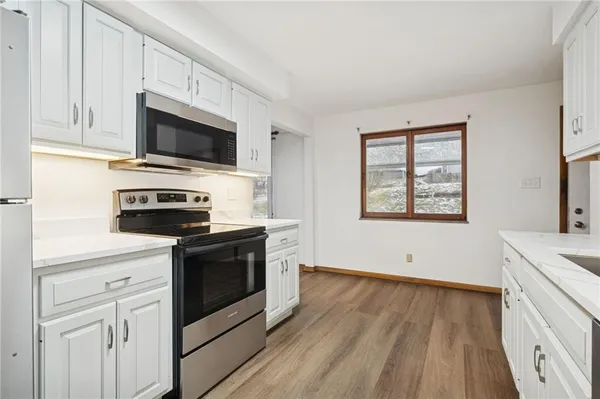 a kitchen with white cabinets stainless steel appliances and sink