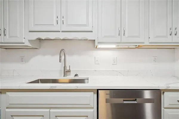 a kitchen with white cabinets and a sink