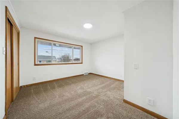 an empty room with windows and closet