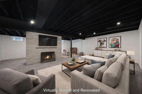 a living room with furniture a fireplace and a flat screen tv