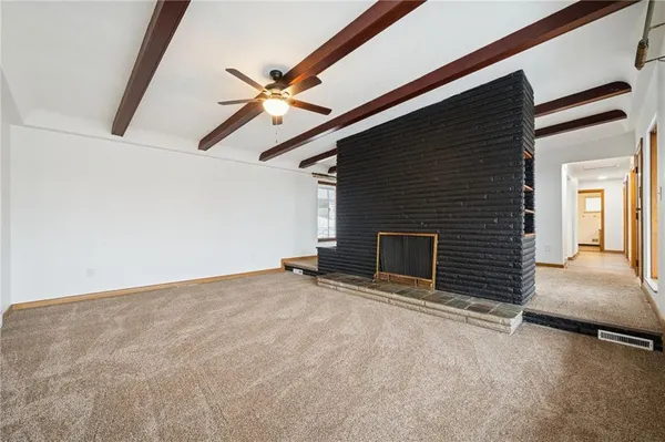 a view of empty room with fireplace and fan