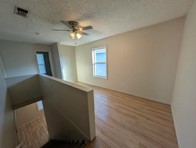 a view of a livingroom with a ceiling fan and wooden floor