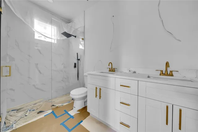 a bathroom with a sink a toilet a shower and a mirror