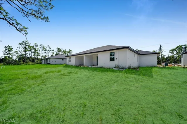 a white house that has a big yard with wooden fence
