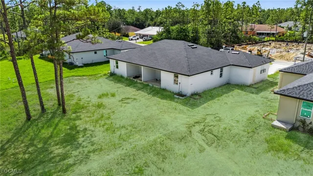a aerial view of a house in a big yard with large trees