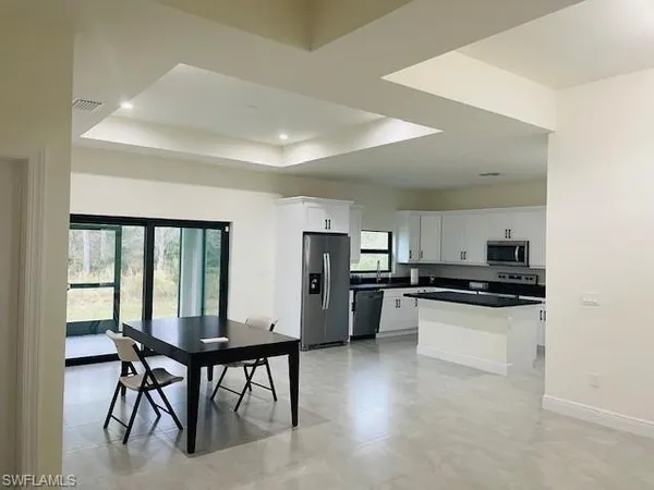 a kitchen with stainless steel appliances kitchen island a refrigerator and a stove top oven