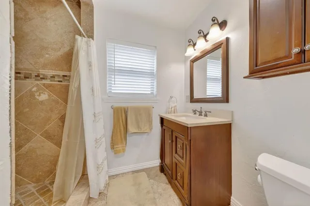a bathroom with a sink toilet and shower