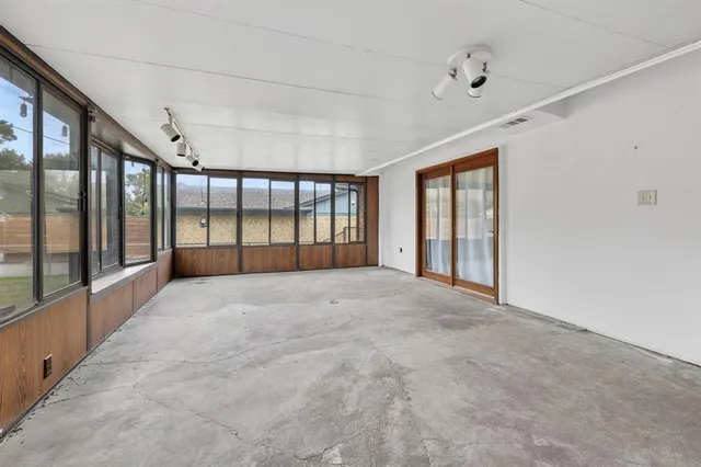 a view of an empty room with large windows