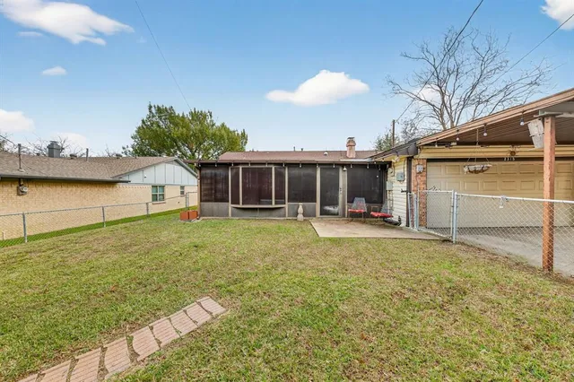 a view of a house with backyard and sitting area