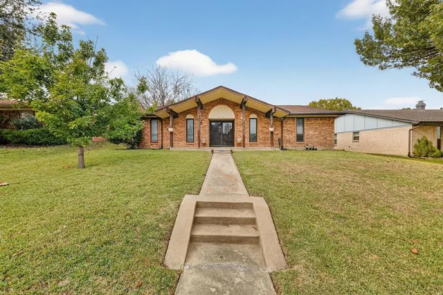 a front view of a house with a yard and trees