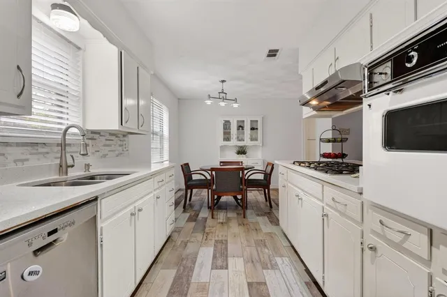 a kitchen with granite countertop a sink appliances cabinets and furniture