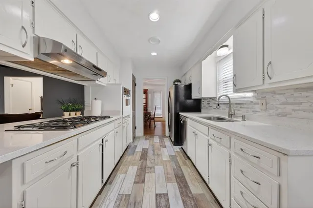 a large kitchen with stainless steel appliances granite countertop a lot of counter space and wooden floors