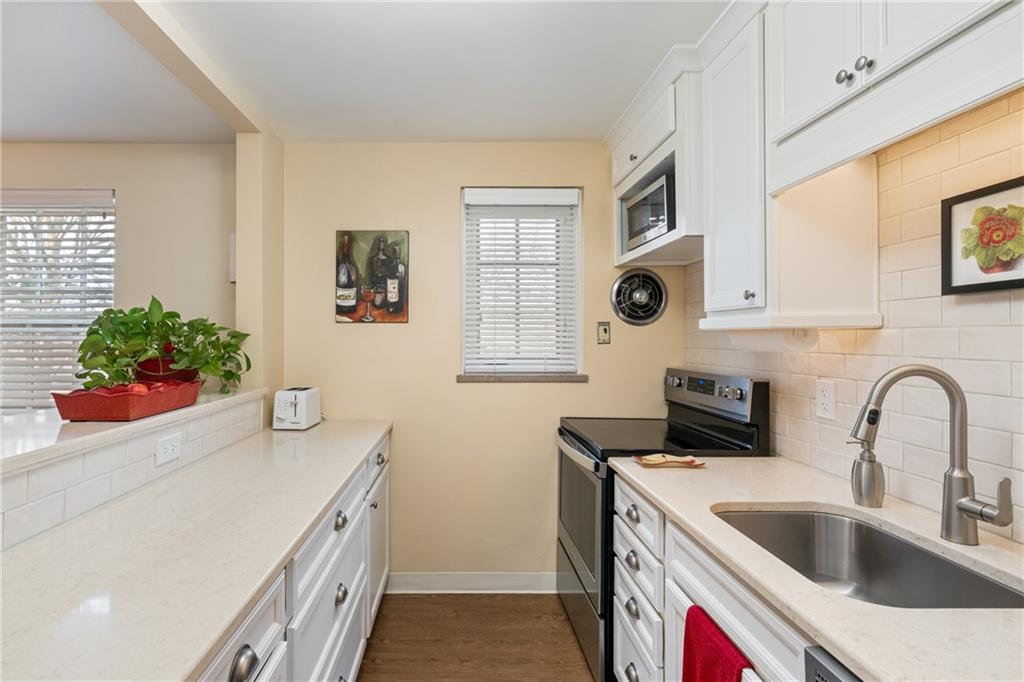415 Bigham Street, Unit 23 Pittsburgh, PA 15211 - Photo 12 of 24 a kitchen with stainless steel appliances a sink a stove and a microwave