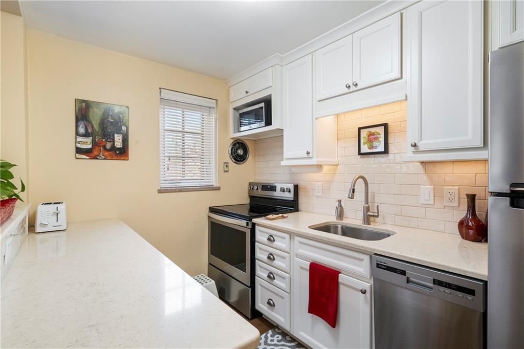415 Bigham Street, Unit 23 Pittsburgh, PA 15211 - Photo 10 of 24 a kitchen with stainless steel appliances granite countertop a sink stove and cabinets
