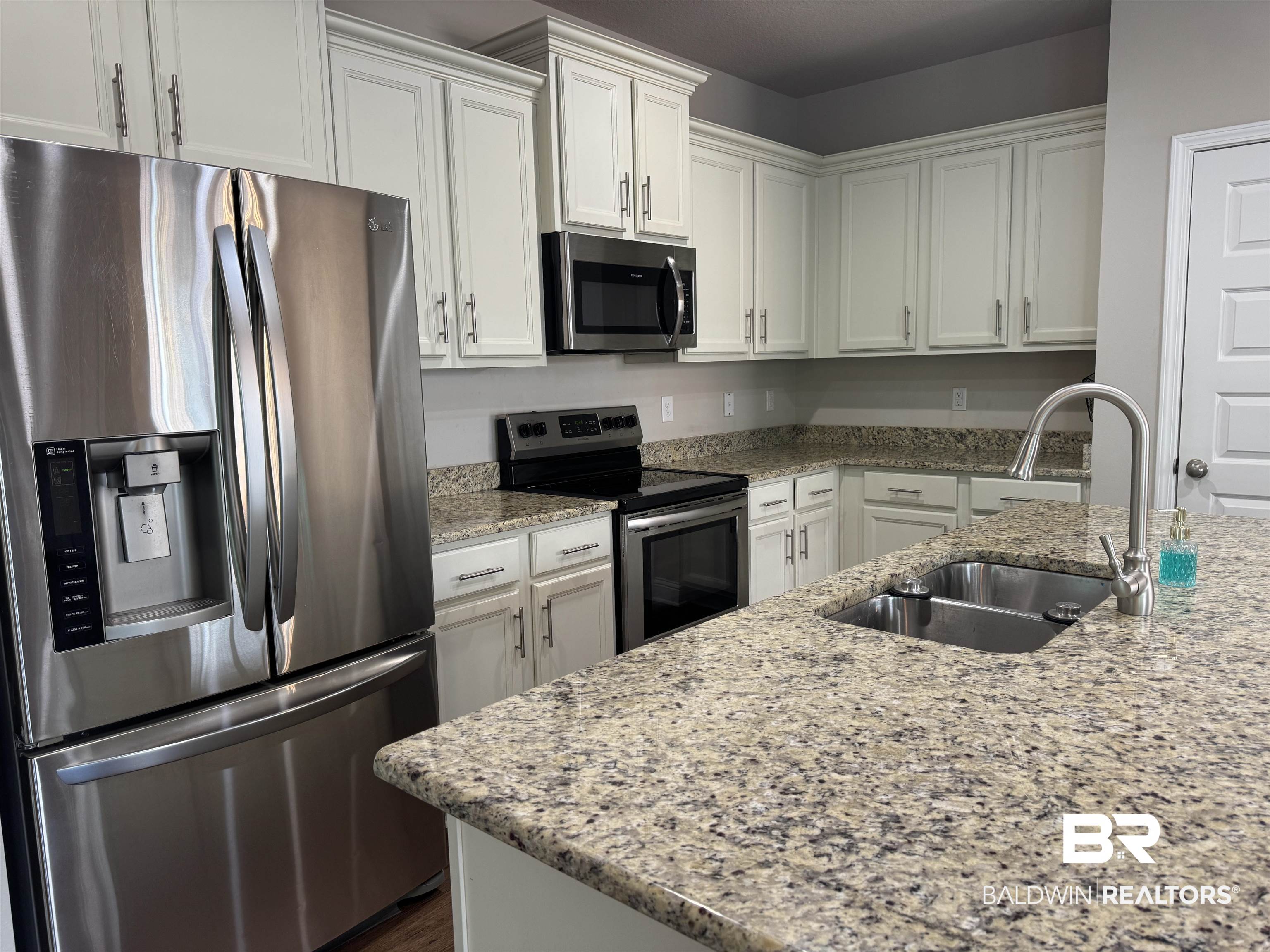 6811 Spaniel Drive, Unit C Daphne, AL 36527 - Photo 9 of 33 Kitchen featuring stainless steel appliances, a sink, white cabinetry, and light stone counters