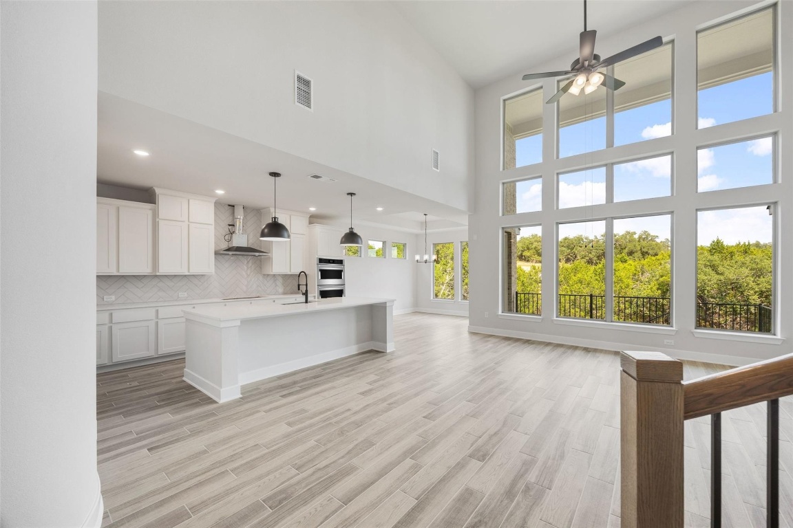 1417 Rodeo Ridge Drive Georgetown, TX 78628 - Photo 2 of 37 Unfurnished living room featuring healthy amount of natural light, a high ceiling, ceiling fan, light wood-style flooring, and recessed lighting
