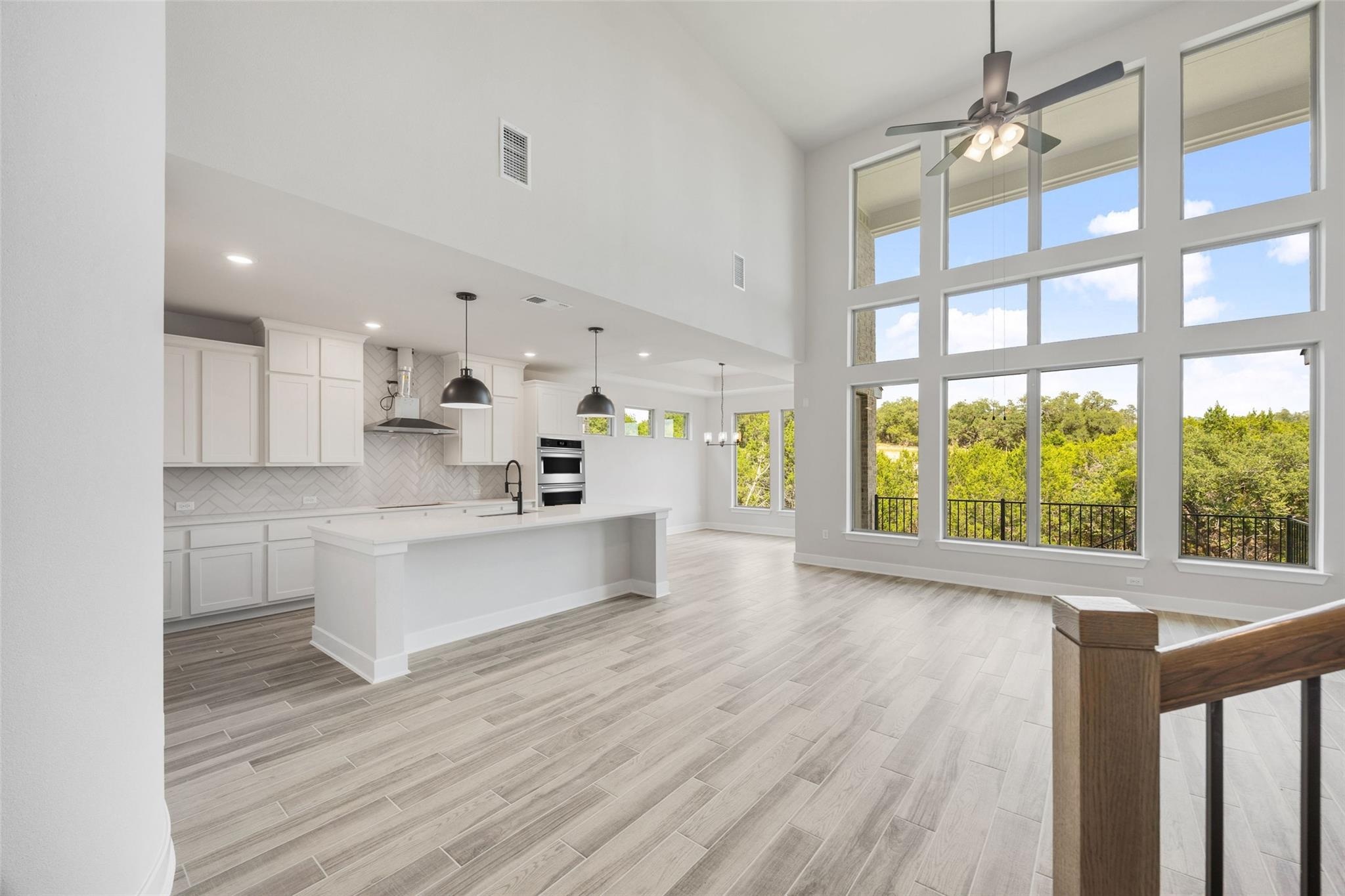 1417 Rodeo Ridge Drive Georgetown, TX 78628 - Photo 2 of 37 Unfurnished living room featuring healthy amount of natural light, a high ceiling, ceiling fan, light wood-style flooring, and recessed lighting