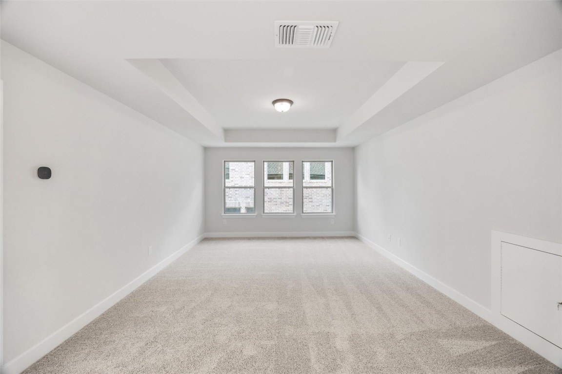 1417 Rodeo Ridge Drive Georgetown, TX 78628 - Photo 22 of 37 Spare room featuring a raised ceiling and light carpet