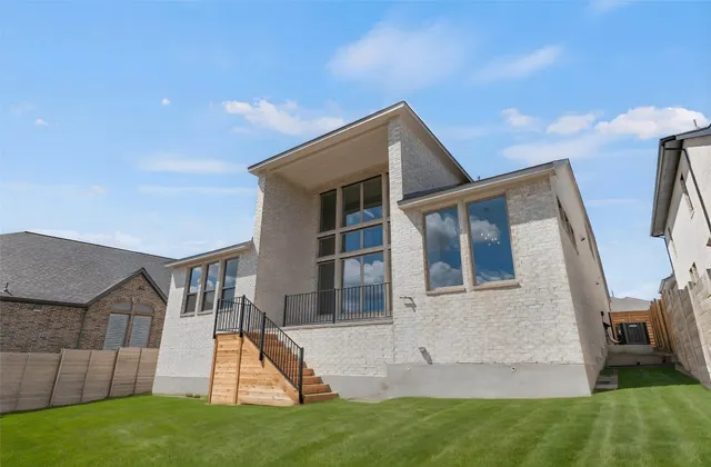 a front view of a house with a garden and yard