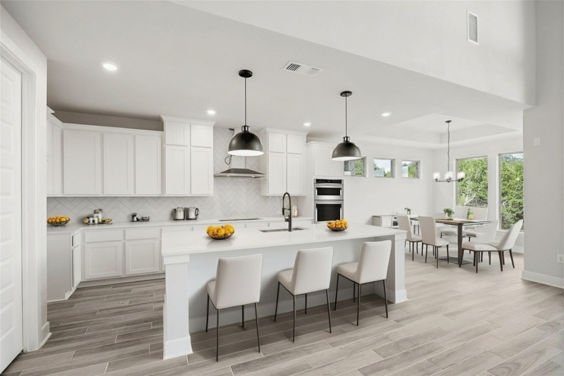 1417 Rodeo Ridge Drive Georgetown, TX 78628 - Photo 7 of 37 Kitchen with decorative backsplash, a kitchen breakfast bar, decorative light fixtures, light wood-style flooring, and recessed lighting