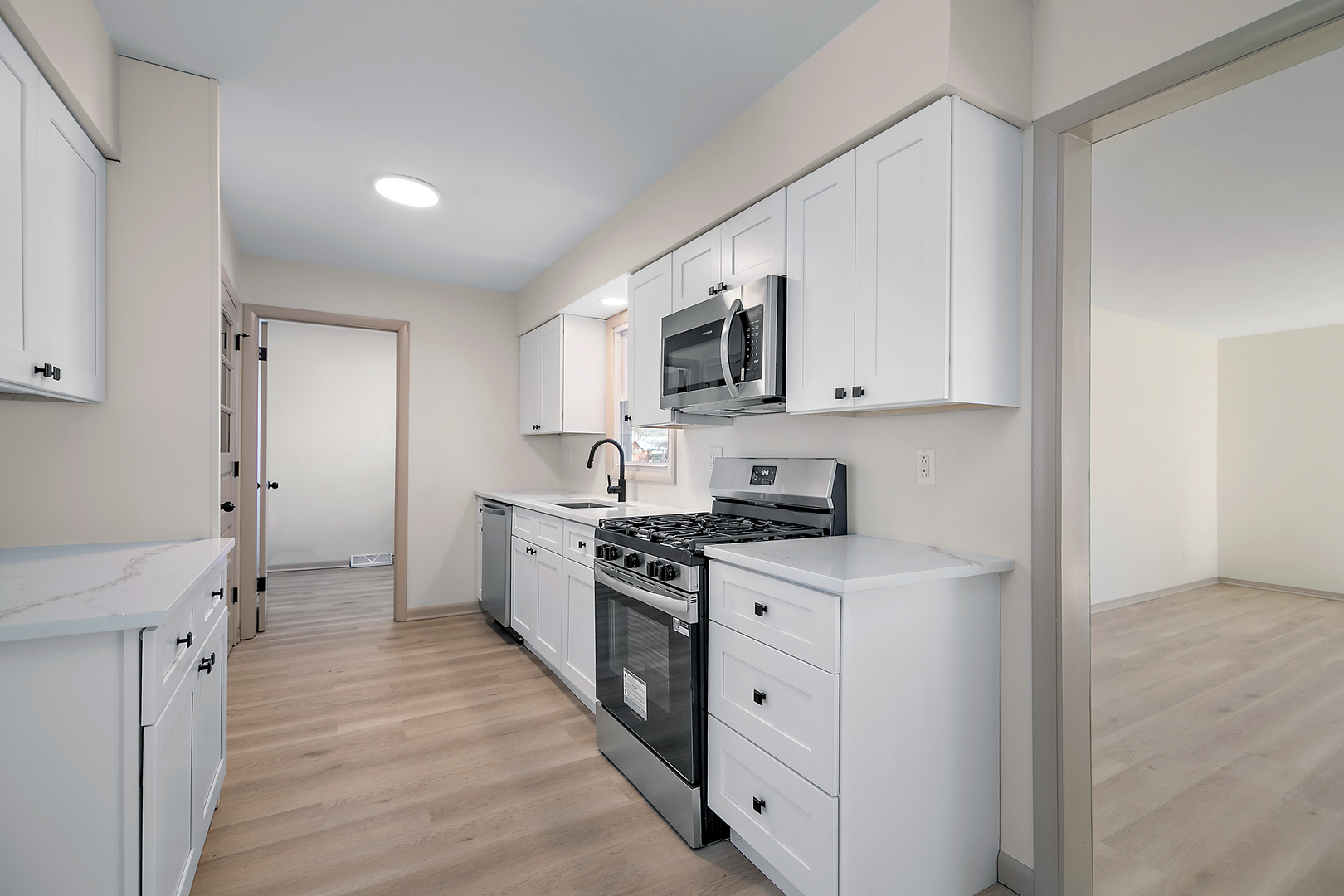 208 Sycamore Lane Momence, IL 60954 - Photo 6 of 19 a kitchen with stainless steel appliances a stove top oven a sink a refrigerator white cabinets and wooden floor