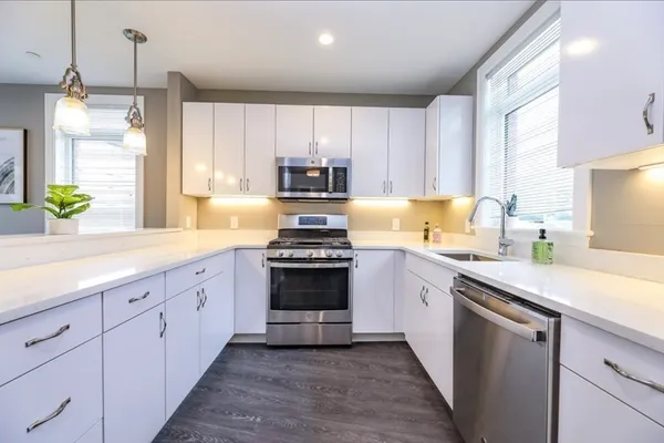 a kitchen with granite countertop a sink stainless steel appliances and cabinets