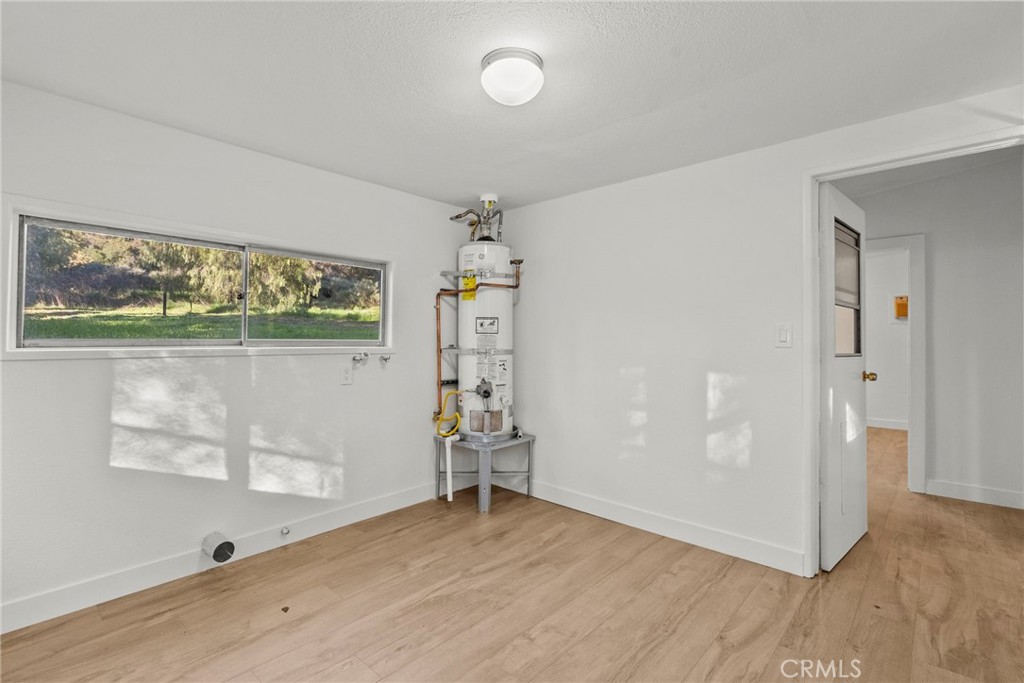 30541 Hasley Canyon Road Castaic, CA 91384 - Photo 17 of 31 an empty room with wooden floor and windows