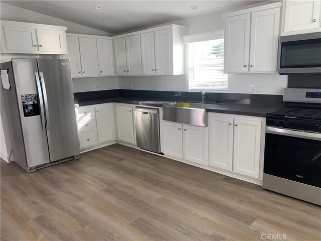 a kitchen with granite countertop white cabinets and stainless steel appliances