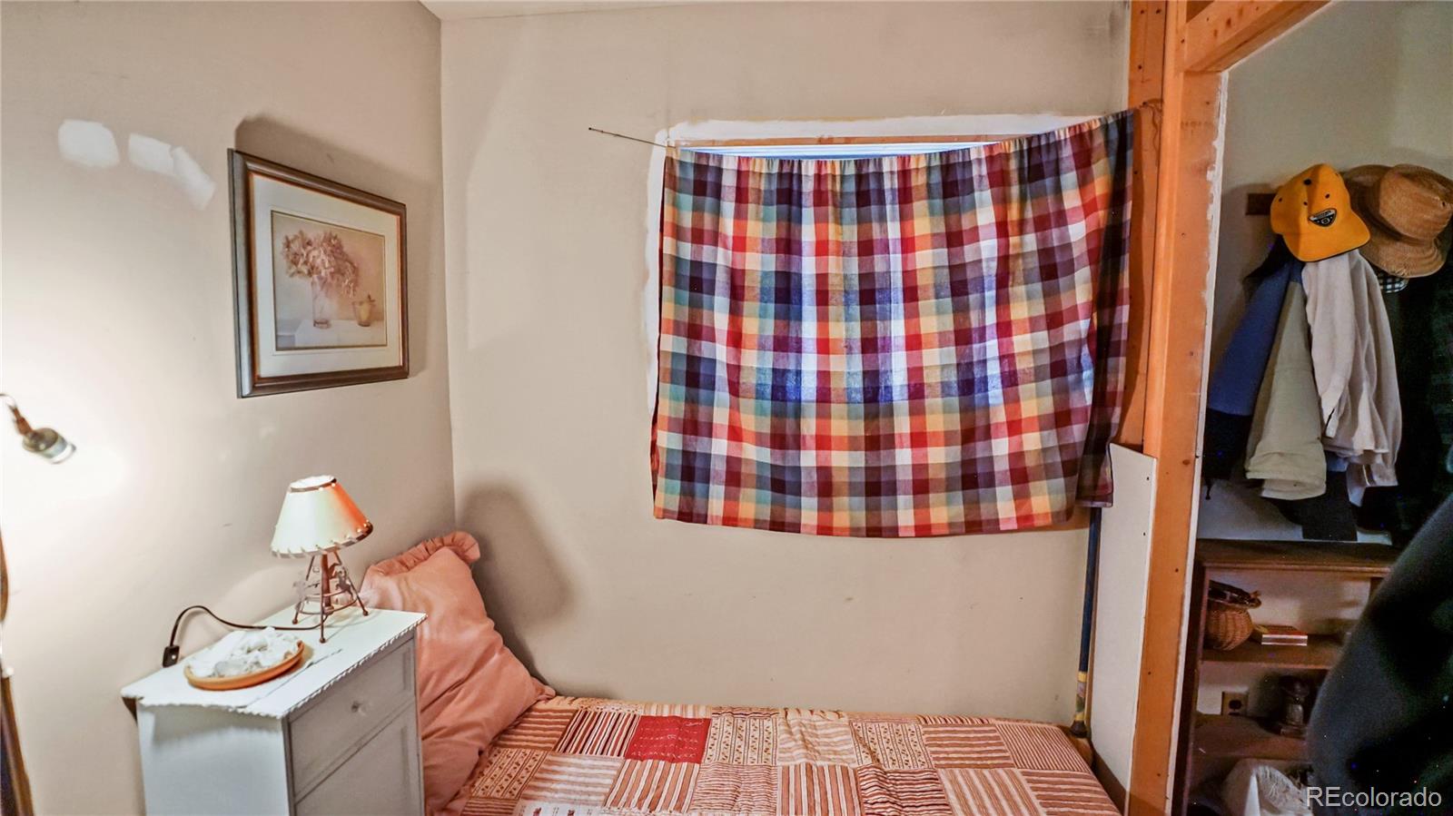 109 Wolf Road Bailey, CO 80421 - Photo 8 of 12 a bedroom with a bed and wooden floor