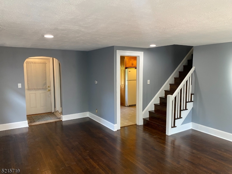 36 Elm Road Caldwell, NJ 07006 - Photo 5 of 28 an empty room with wooden floor and stairs