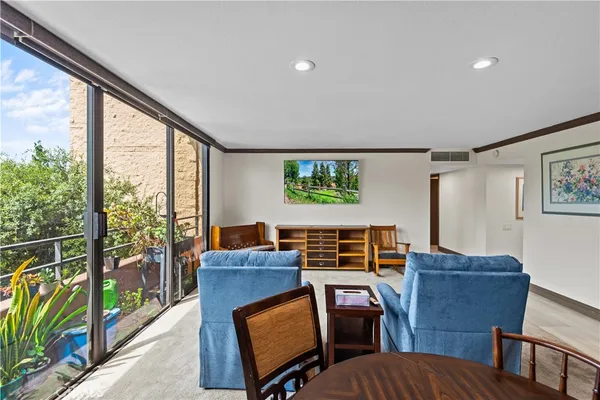 a living room with furniture a flat screen tv and windows