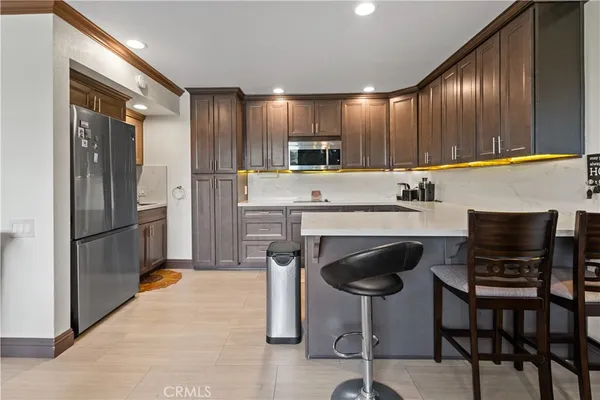 a kitchen with kitchen island a counter top space cabinets and stainless steel appliances