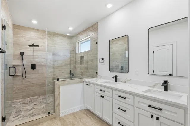 a bathroom with a double vanity sink mirror and shower