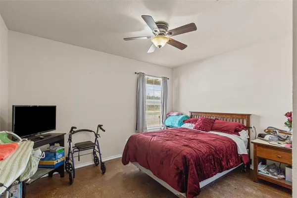 a spacious bedroom with a bed and a flat screen tv
