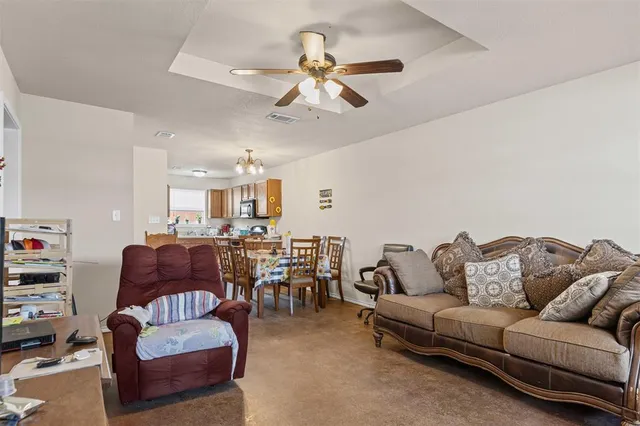 a living room with furniture kitchen view and a chandelier