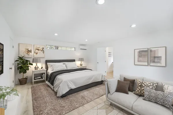 a bedroom with a bed couch and potted plant