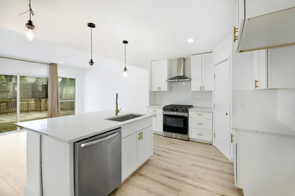 a kitchen with stainless steel appliances granite countertop a sink and a refrigerator