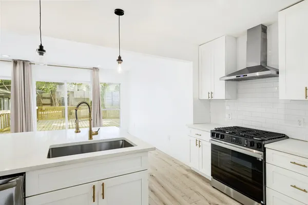 a kitchen with stainless steel appliances a sink stove and cabinets