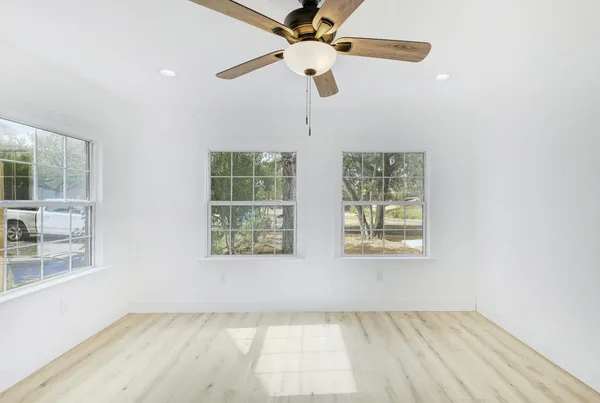 an empty room with fan and windows