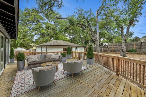 a view of a roof deck with table and chairs under an umbrella with wooden fence