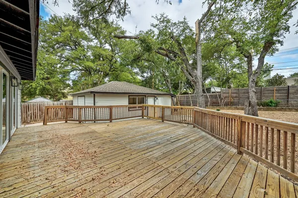 a porch with wooden floor and fence