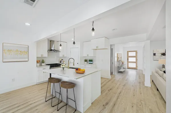 a kitchen with white cabinets and stainless steel appliances