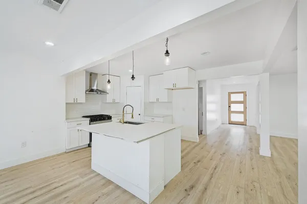 a kitchen with stainless steel appliances granite countertop a sink stove and wooden floor