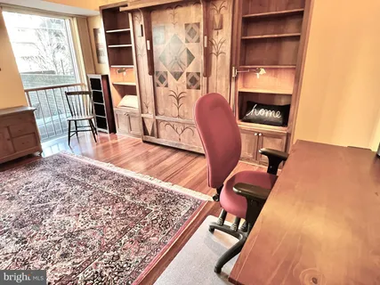 a view of a workspace with furniture and a window