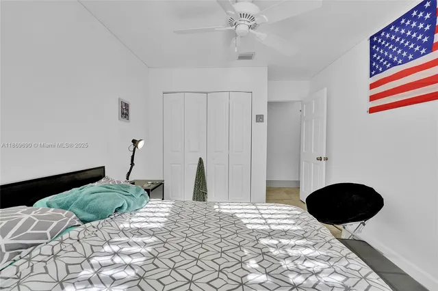 a spacious bedroom with a bed and a flat screen tv