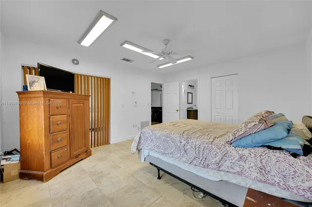 a spacious bedroom with a bed and a chandelier