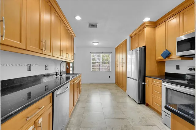 a kitchen with stainless steel appliances granite countertop a stove microwave and refrigerator